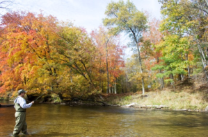 a man standing next to a river