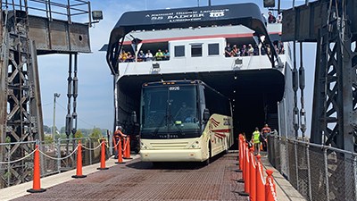 motorcoach a bus that is parked on the side of a fence